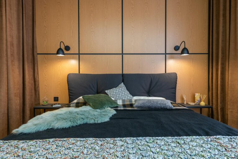 A stylish modern bedroom featuring a comfortable bed, soft textiles, and warm lighting.