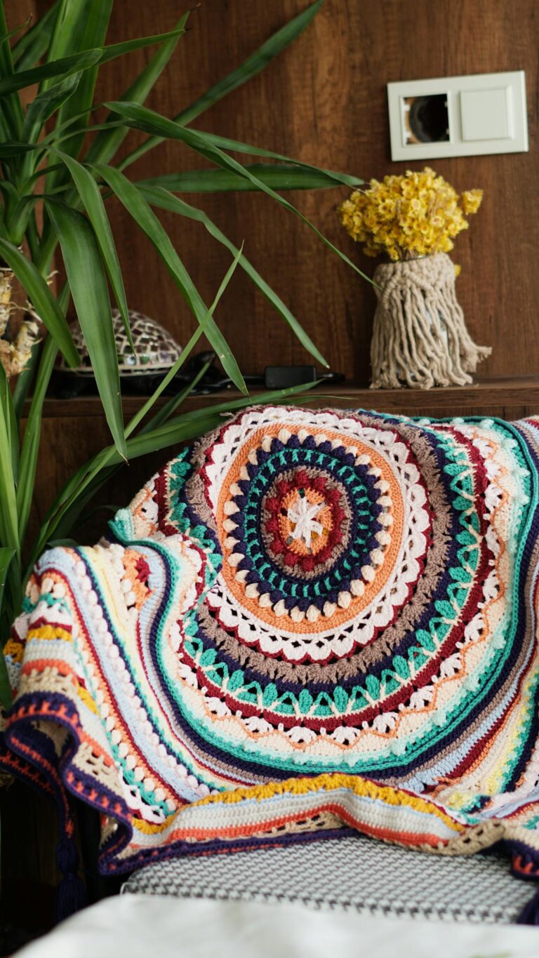 Vibrant crochet blanket adding warmth to a cozy indoor setting with plants and decor.
